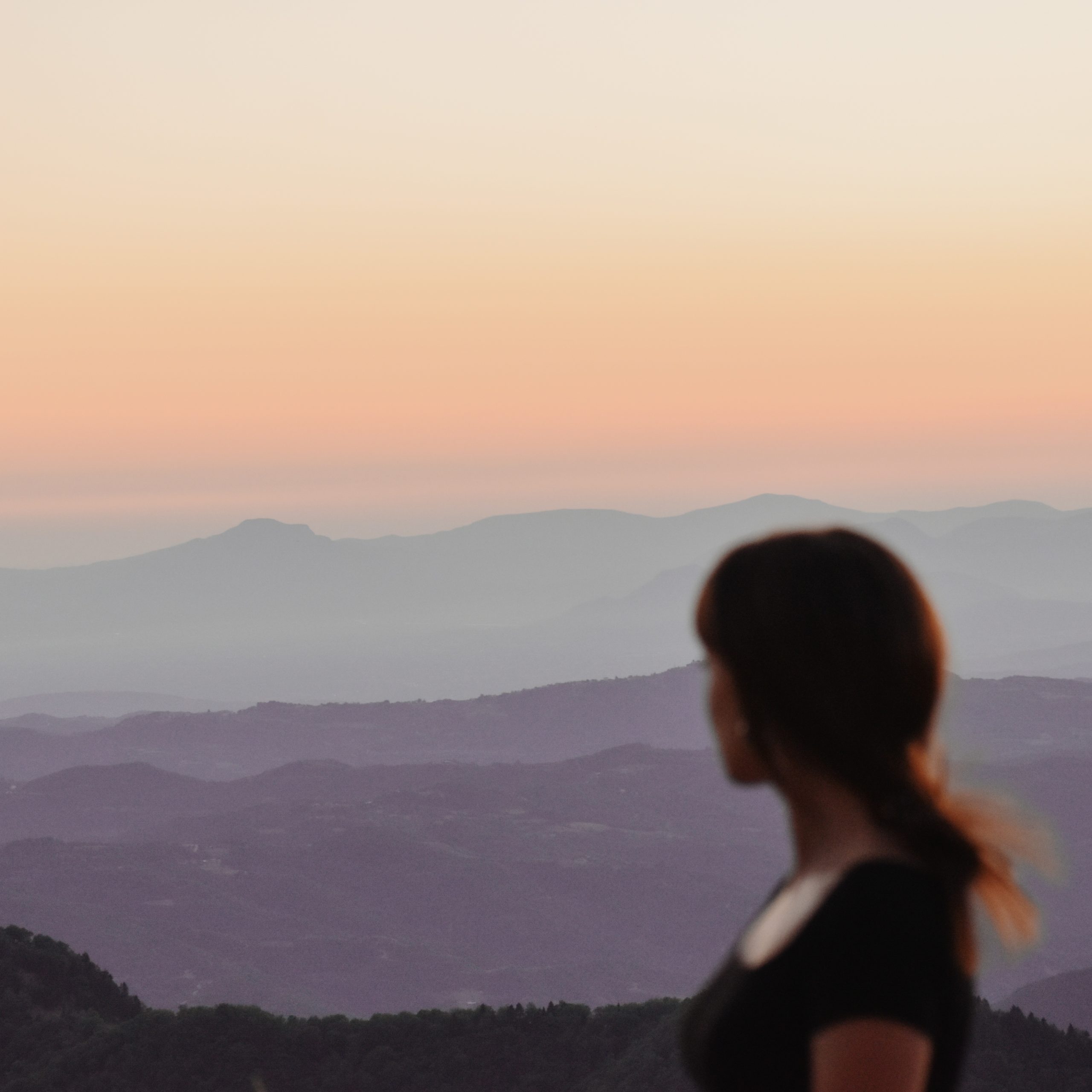 mujer desenfocada mirando un horizonte de montañas